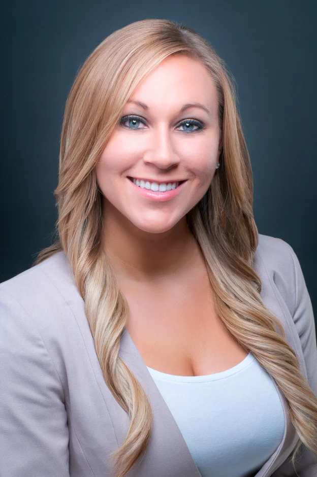 professional headshot portrait in a well-lit studio, featuring a confident individual with a friendly smile