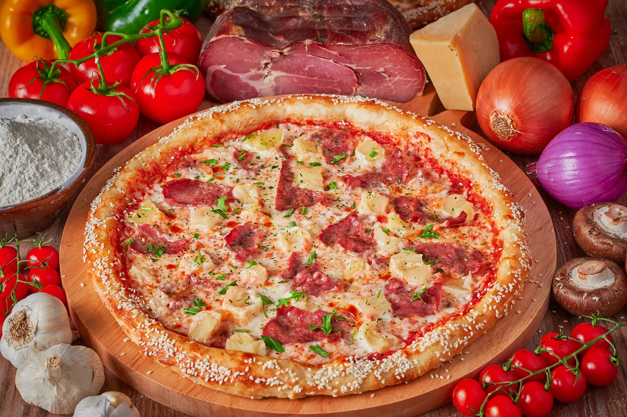 Photograph of a mouthwatering Pineapple Pizza surrounded by a colorful array of fresh vegetables, beautifully captured in food photography.
