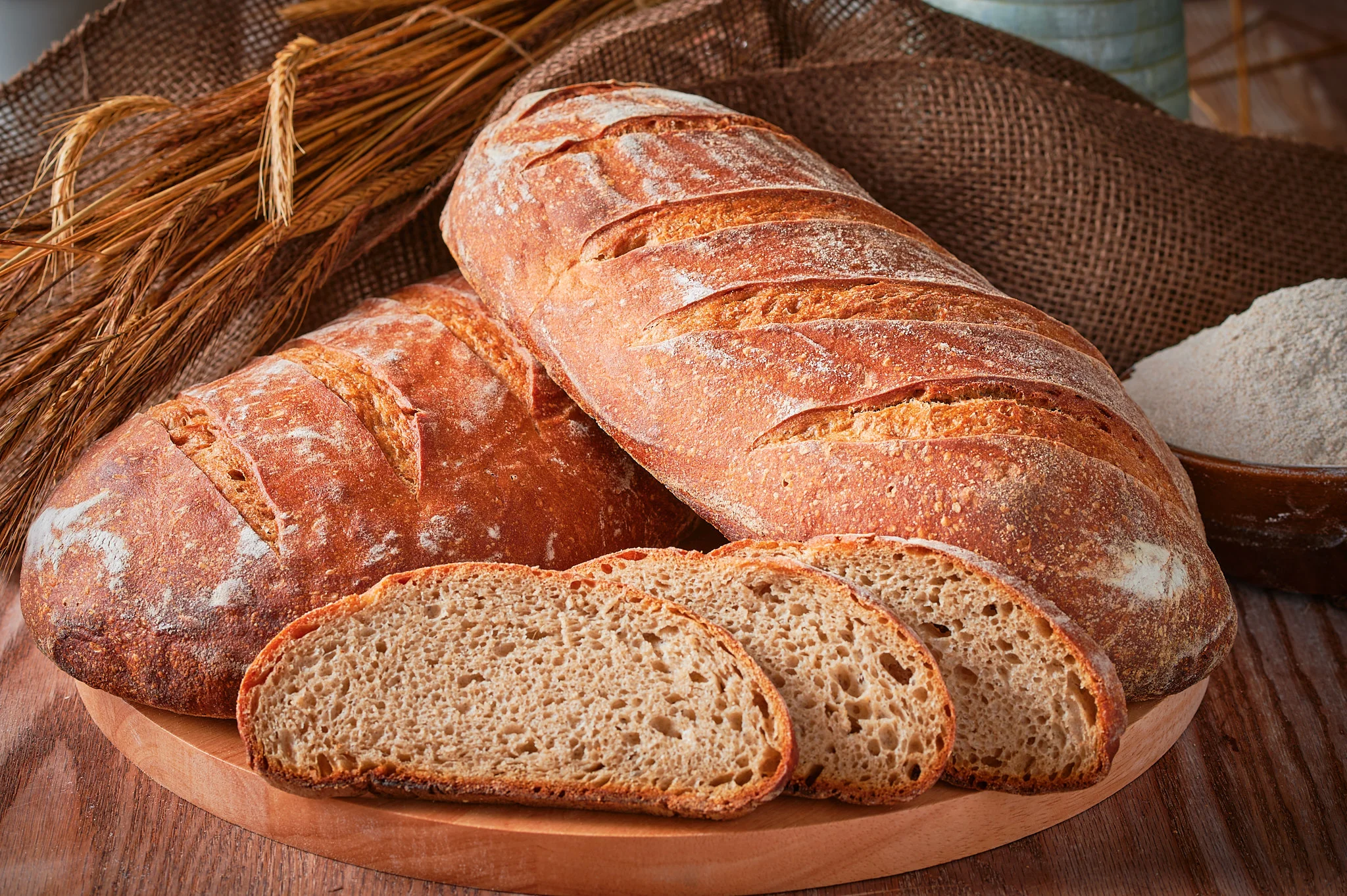 Freshly baked bread loafs and slices, beautifully captured in a food photography composition.